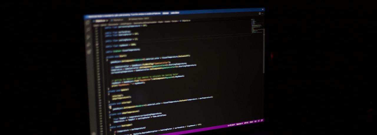 Software developer working with AI coding tools on laptop screen showing code automation